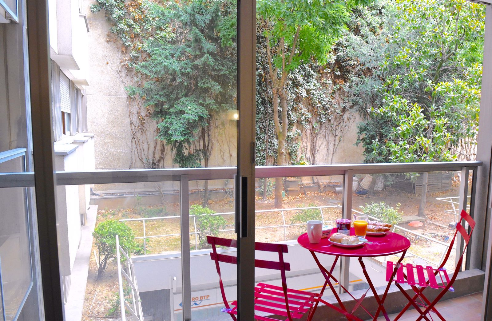Balcony terrace with breakfast setup overlooking Parisian gardens at Short Stay Paris apartment