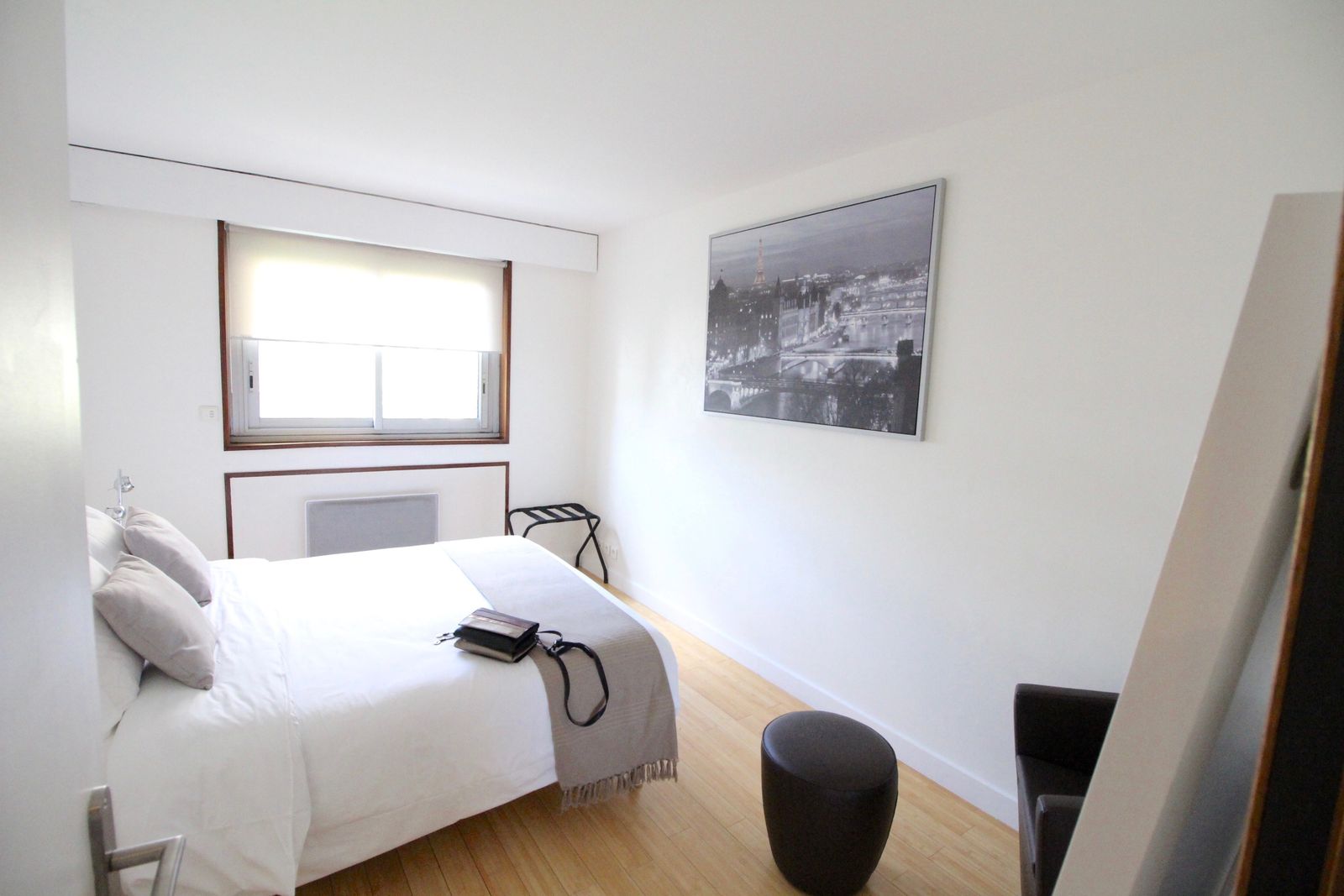 Chambre avec lit blanc et art mural parisien